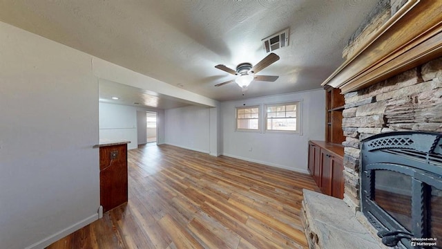 unfurnished living room featuring a textured ceiling, hardwood / wood-style flooring, and ceiling fan