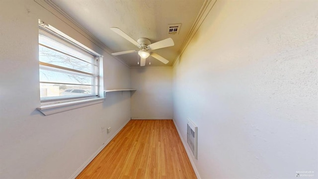 spare room with ceiling fan, ornamental molding, and light wood-type flooring