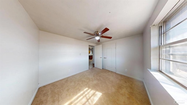 carpeted spare room with ceiling fan