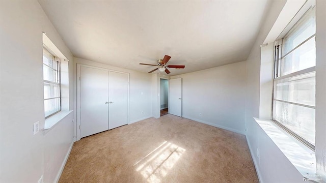 unfurnished bedroom featuring light colored carpet and ceiling fan