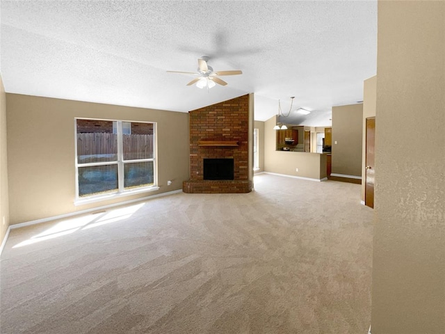 unfurnished living room featuring light carpet, a brick fireplace, a textured ceiling, vaulted ceiling, and ceiling fan