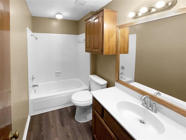 full bathroom with vanity, bathing tub / shower combination, toilet, a textured ceiling, and wood-type flooring