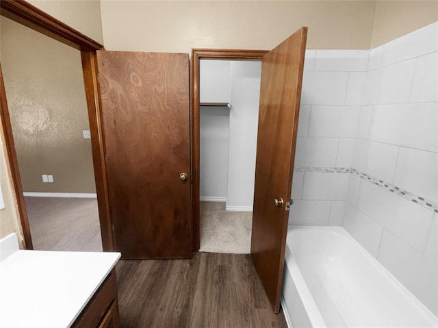 bathroom featuring a bathing tub, vanity, and wood-type flooring