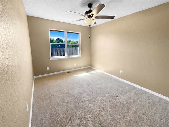 spare room featuring carpet flooring, ceiling fan, and a textured ceiling