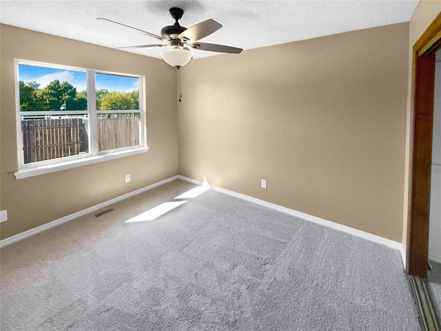 empty room featuring a textured ceiling, carpet floors, and ceiling fan