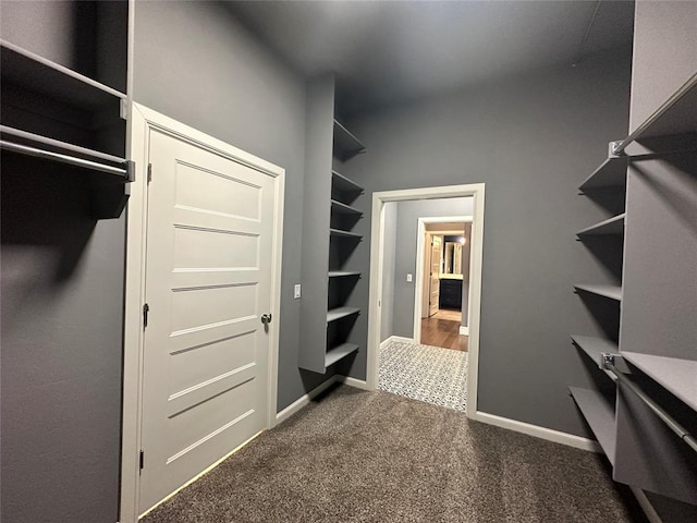 spacious closet with dark colored carpet