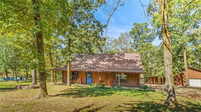 cabin with an outdoor structure, a front yard, and a garage