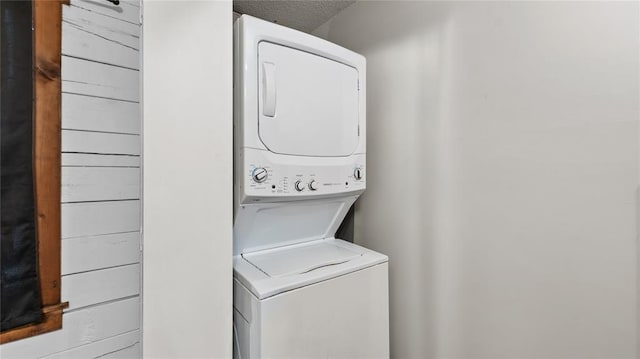 laundry area featuring a textured ceiling and stacked washer and clothes dryer