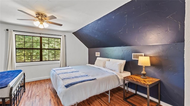 bedroom with ceiling fan, vaulted ceiling, and hardwood / wood-style flooring