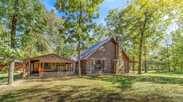 rear view of house featuring covered porch and a yard