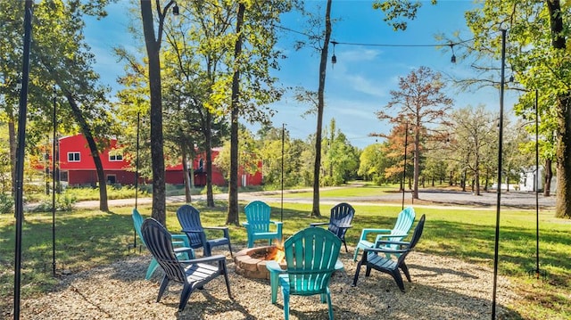 view of community featuring a yard and an outdoor fire pit