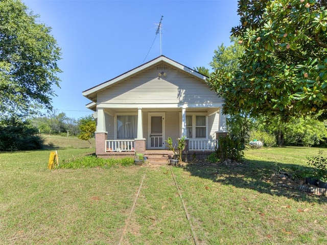 bungalow featuring a front lawn and a porch