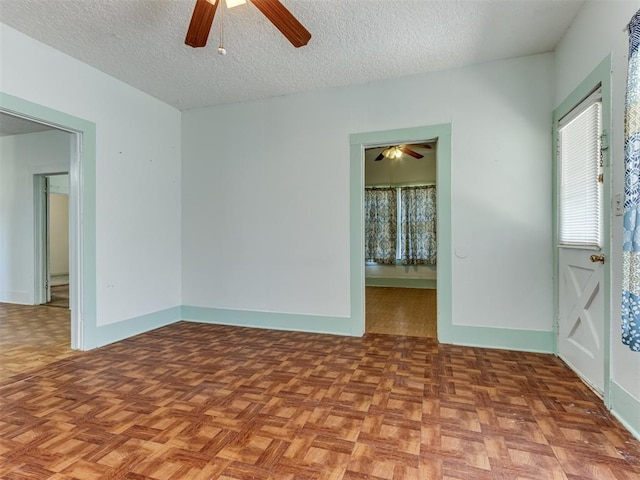 unfurnished room featuring a textured ceiling, ceiling fan, and light parquet flooring