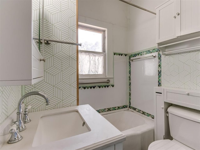 bathroom with vanity, toilet, and a bathing tub