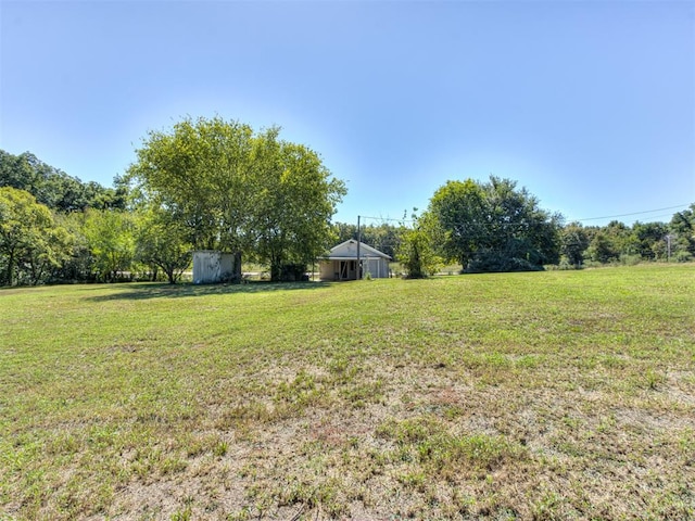 view of yard with a rural view and a storage shed