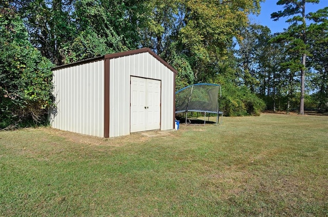 view of outdoor structure featuring a lawn and a trampoline