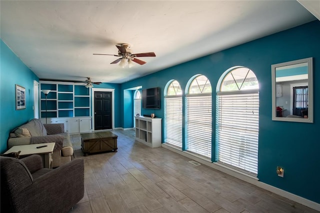 living room with ceiling fan and light wood-type flooring