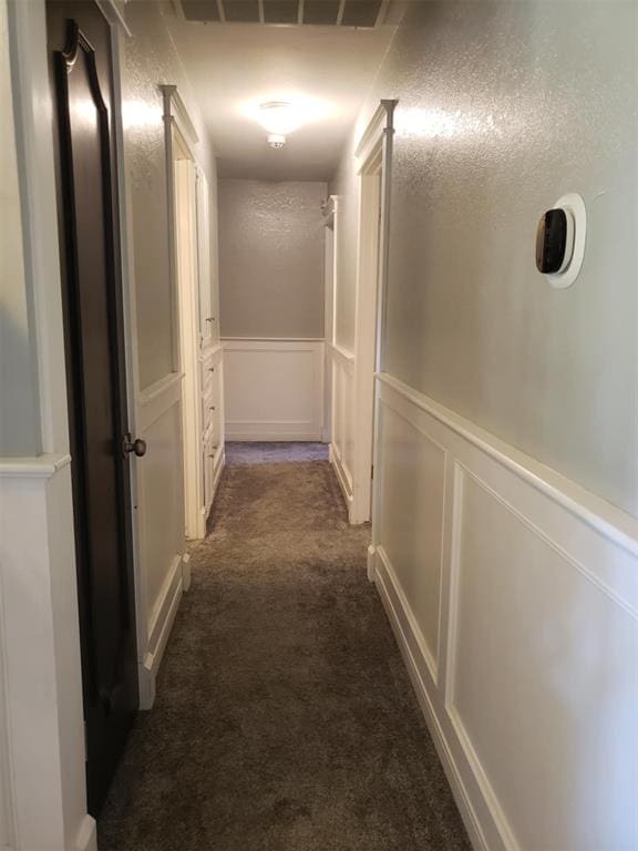 corridor with dark colored carpet