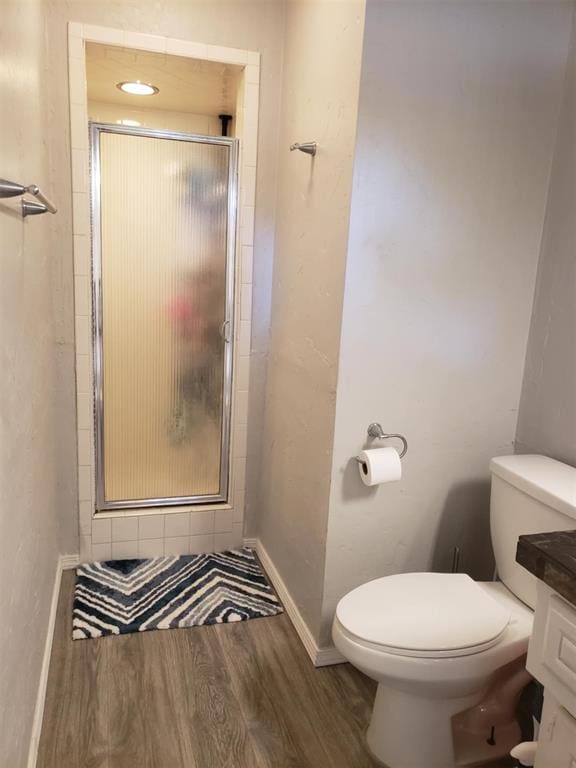 bathroom featuring hardwood / wood-style floors, vanity, an enclosed shower, and toilet