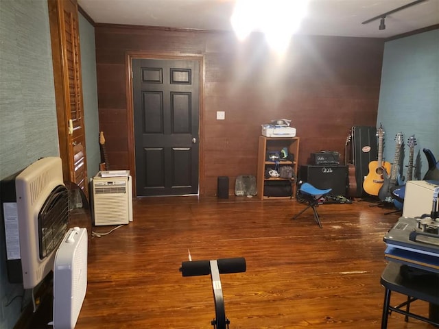 workout area featuring track lighting, dark hardwood / wood-style flooring, and heating unit