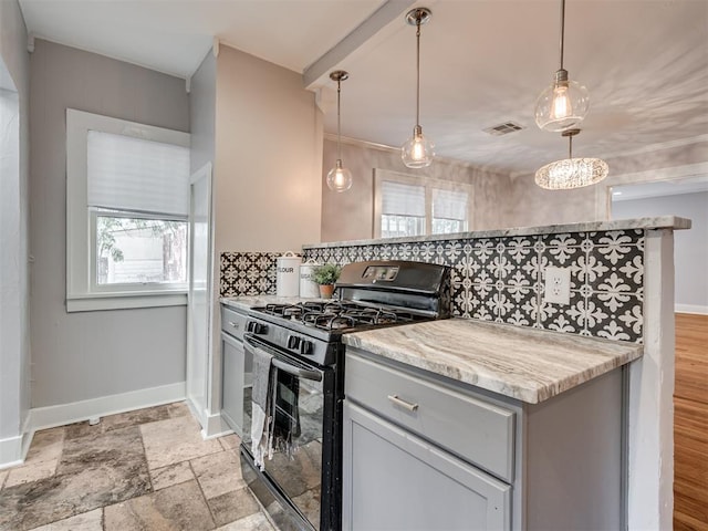 kitchen with black gas range, a healthy amount of sunlight, and backsplash