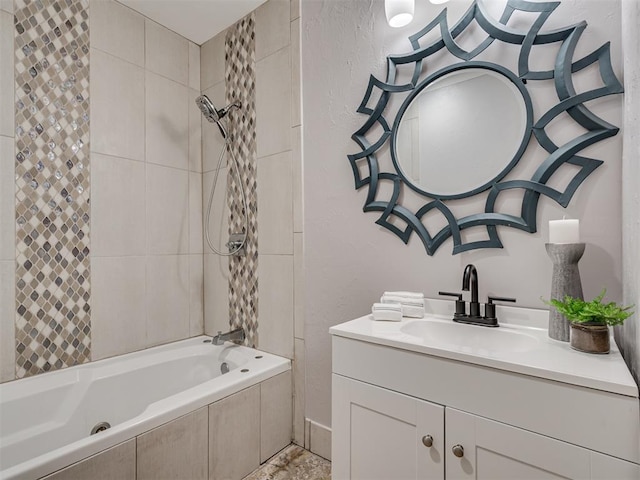 bathroom featuring tiled shower / bath combo and vanity