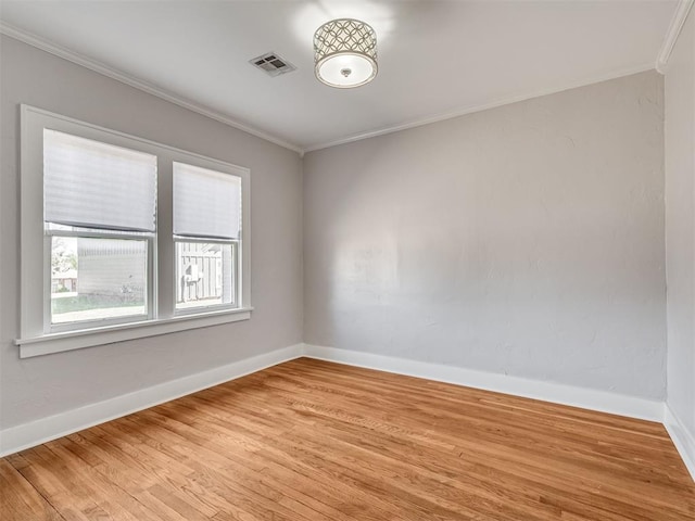 empty room featuring ornamental molding and light wood-type flooring