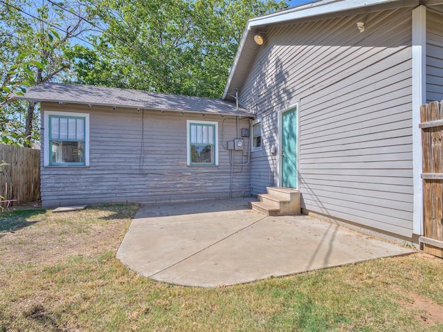 rear view of house with a patio and a lawn