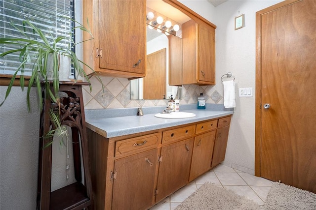 kitchen with light tile patterned flooring, sink, and tasteful backsplash