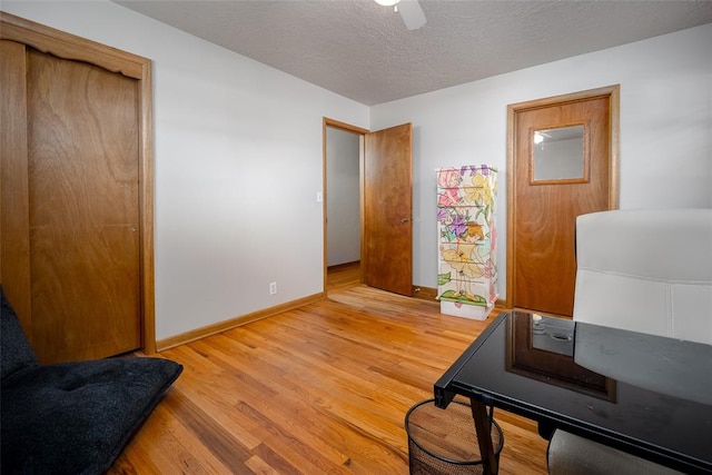 office area featuring ceiling fan, light hardwood / wood-style floors, and a textured ceiling