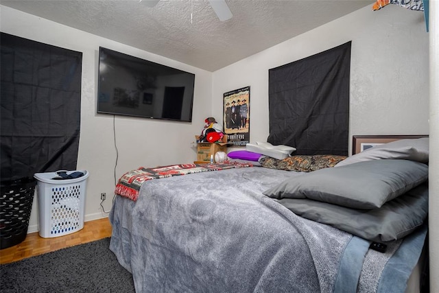 bedroom featuring hardwood / wood-style floors, a textured ceiling, and ceiling fan