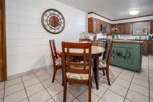 tiled dining room with sink and a textured ceiling