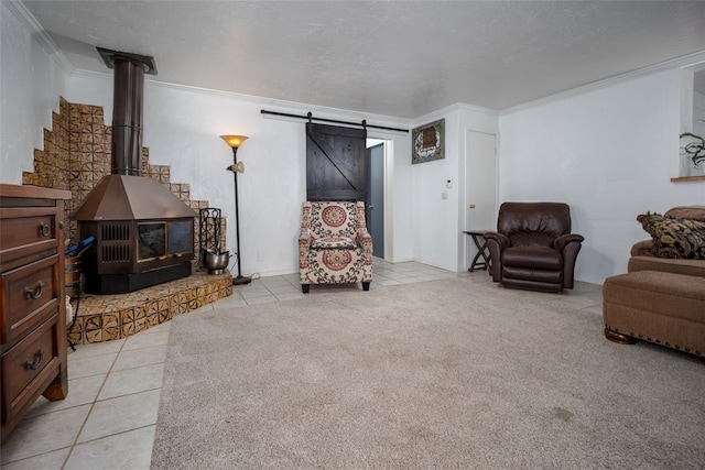 living room featuring ornamental molding, a textured ceiling, light tile patterned floors, a barn door, and a wood stove