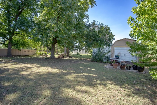 view of yard featuring a garage and an outbuilding