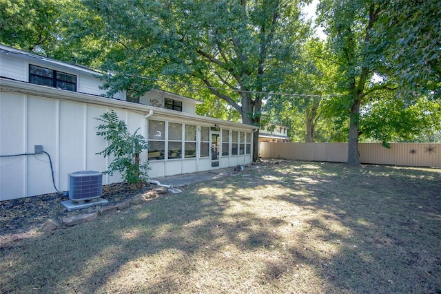 view of yard featuring central air condition unit and a sunroom