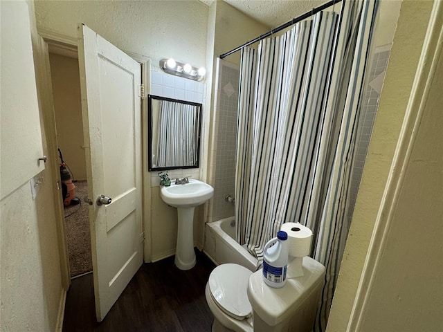 bathroom featuring shower / bathtub combination with curtain, wood-type flooring, and toilet