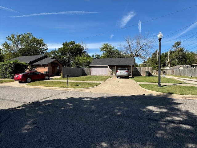 single story home featuring an outbuilding, a front lawn, and a garage