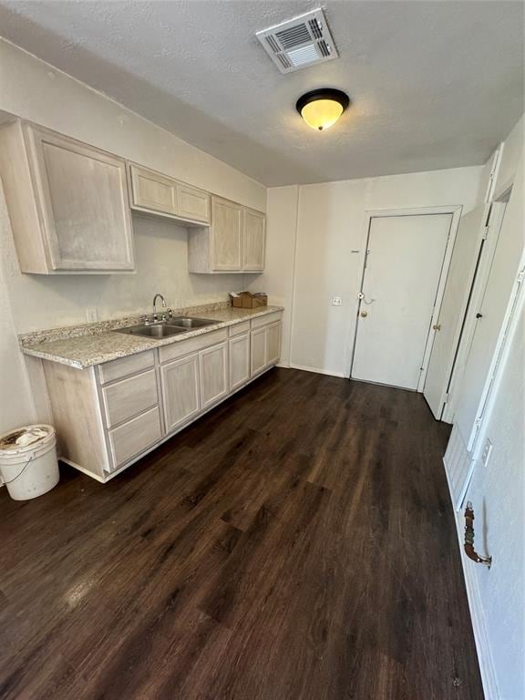 kitchen featuring a textured ceiling, sink, and dark hardwood / wood-style floors