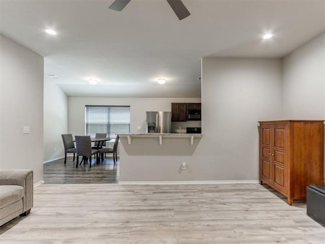 living room featuring ceiling fan and light hardwood / wood-style flooring