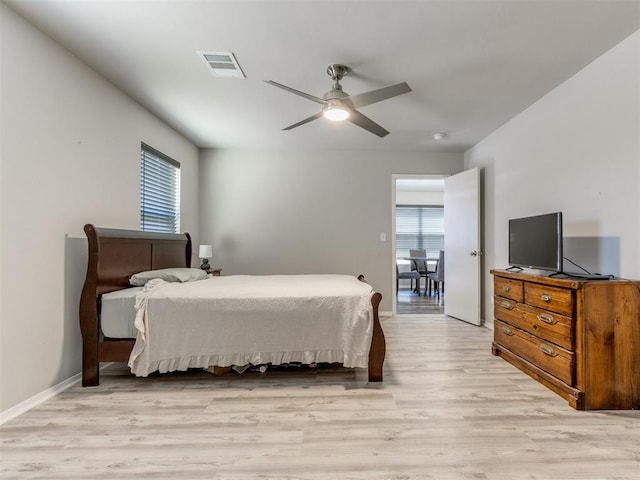 bedroom with multiple windows, ceiling fan, and light wood-type flooring