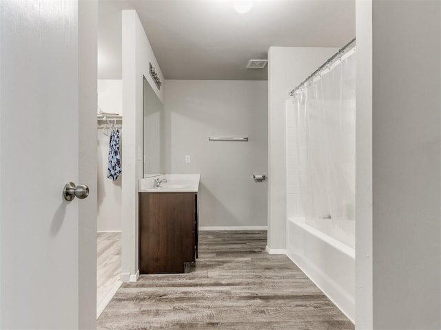 bathroom featuring shower / bathtub combination with curtain, vanity, and wood-type flooring