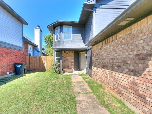 view of exterior entry with a lawn