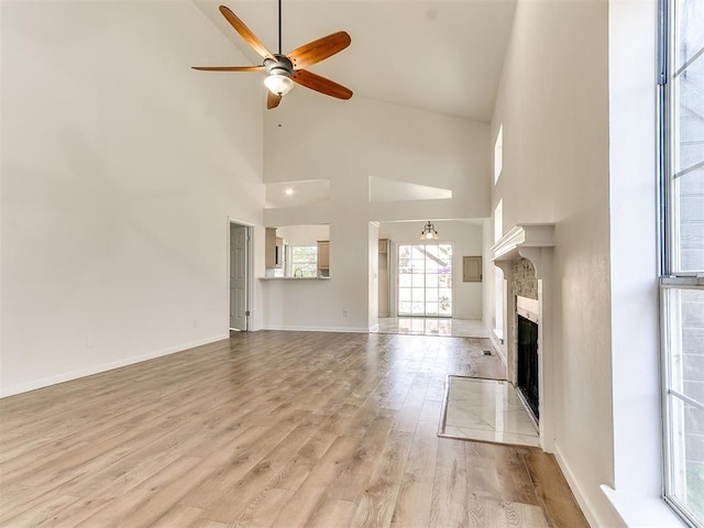 unfurnished living room featuring ceiling fan, light hardwood / wood-style floors, and high vaulted ceiling