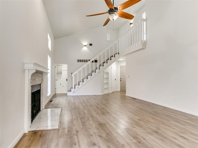 unfurnished living room with ceiling fan, light hardwood / wood-style flooring, and high vaulted ceiling