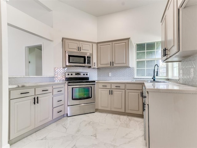 kitchen with sink, stainless steel appliances, and tasteful backsplash