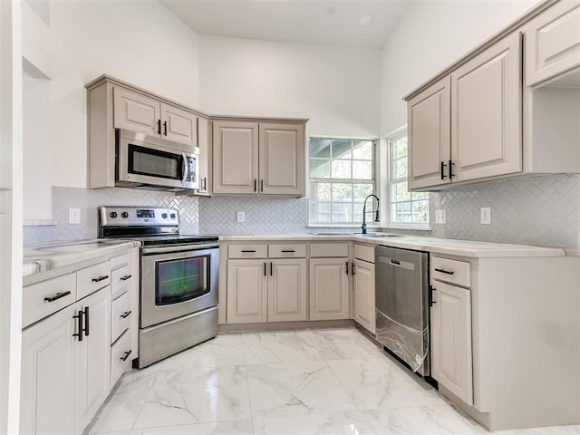 kitchen featuring sink, appliances with stainless steel finishes, and tasteful backsplash