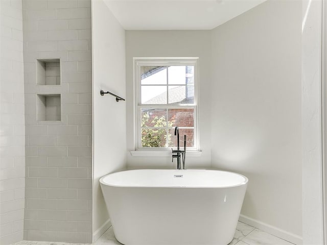 bathroom with a wealth of natural light and a bathtub