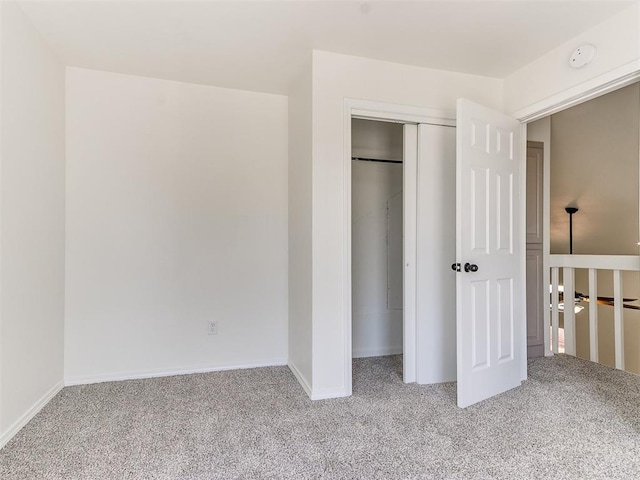 unfurnished bedroom featuring light colored carpet and a closet