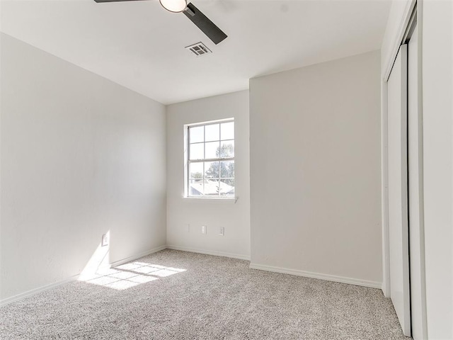 unfurnished bedroom featuring ceiling fan, a closet, and light carpet