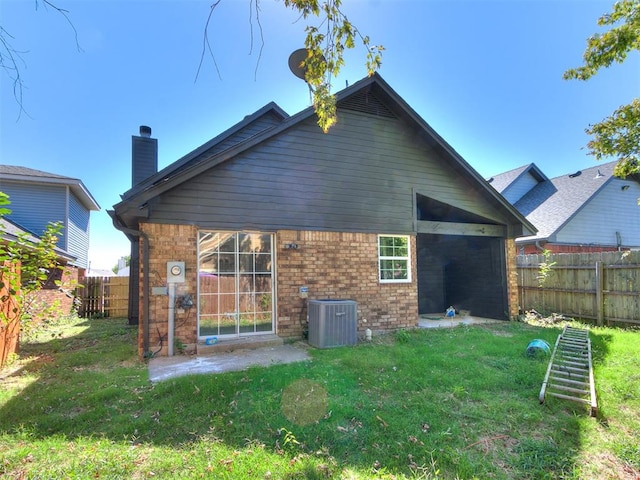 rear view of house with a lawn and central AC unit